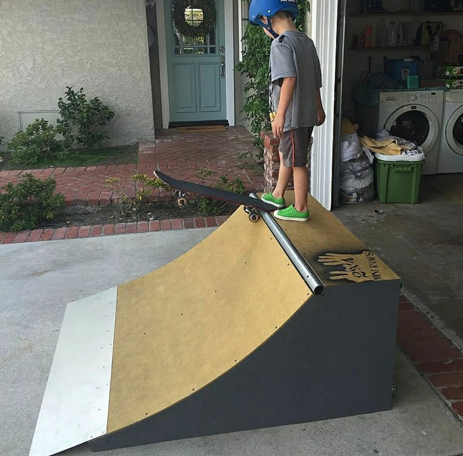 Child on deck of two foot high by four foot wide quarter pipe, preparing to drop in