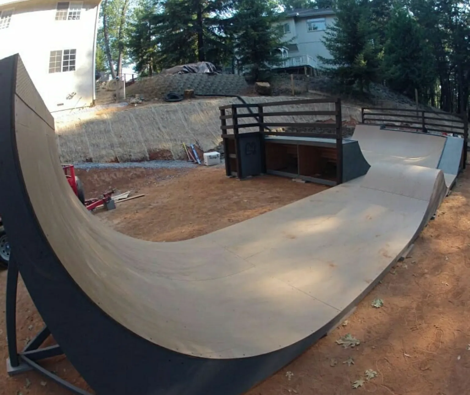 Side view of custom backyard flow park with extensions, sloping coping, bowled corner, and pump bump