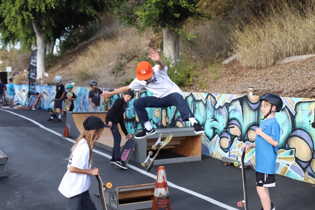 Child kickflipping over safety cone off 2x4 built launch ramp as other children watch